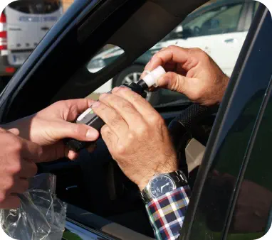 Close-up of an officer handing a breatholyzer to a driver